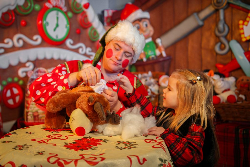 Elf making a teddy bear with a child